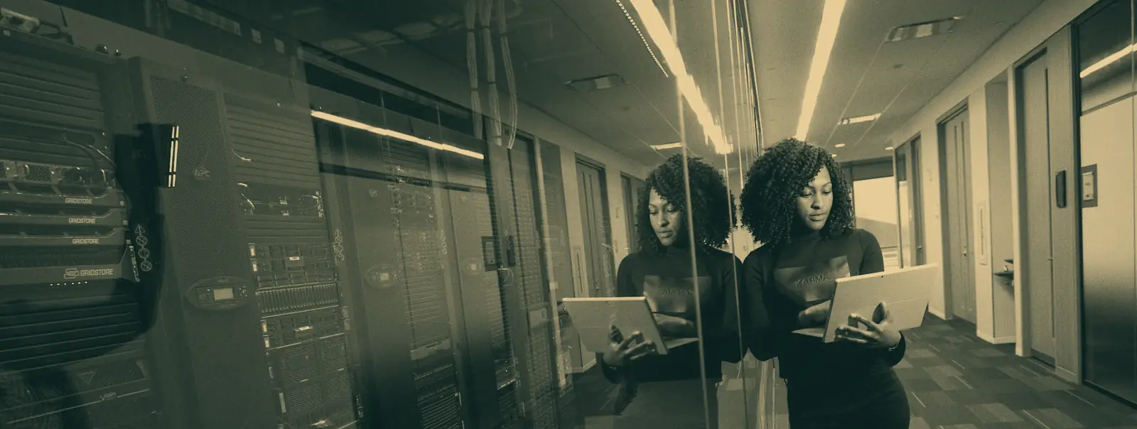 An engineer reviewing infrastructure in a data centre corridor.